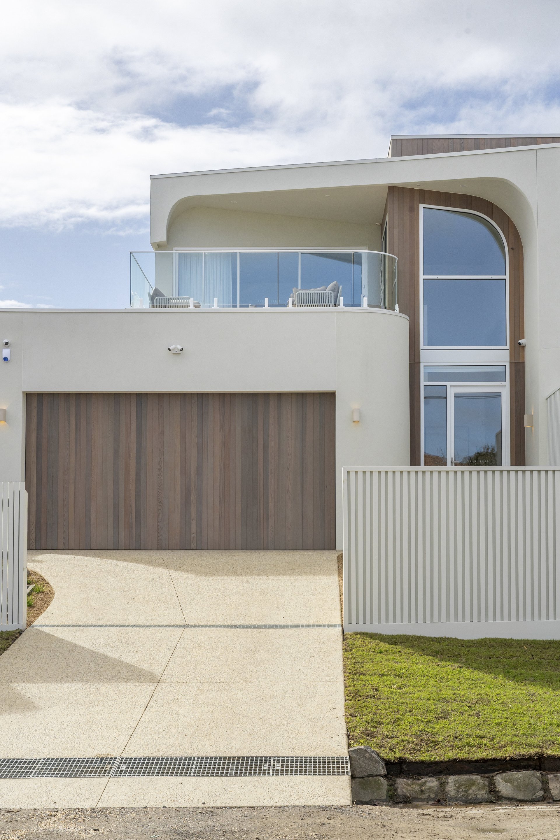 Driveway and curved architectural façade of the Williams Road home